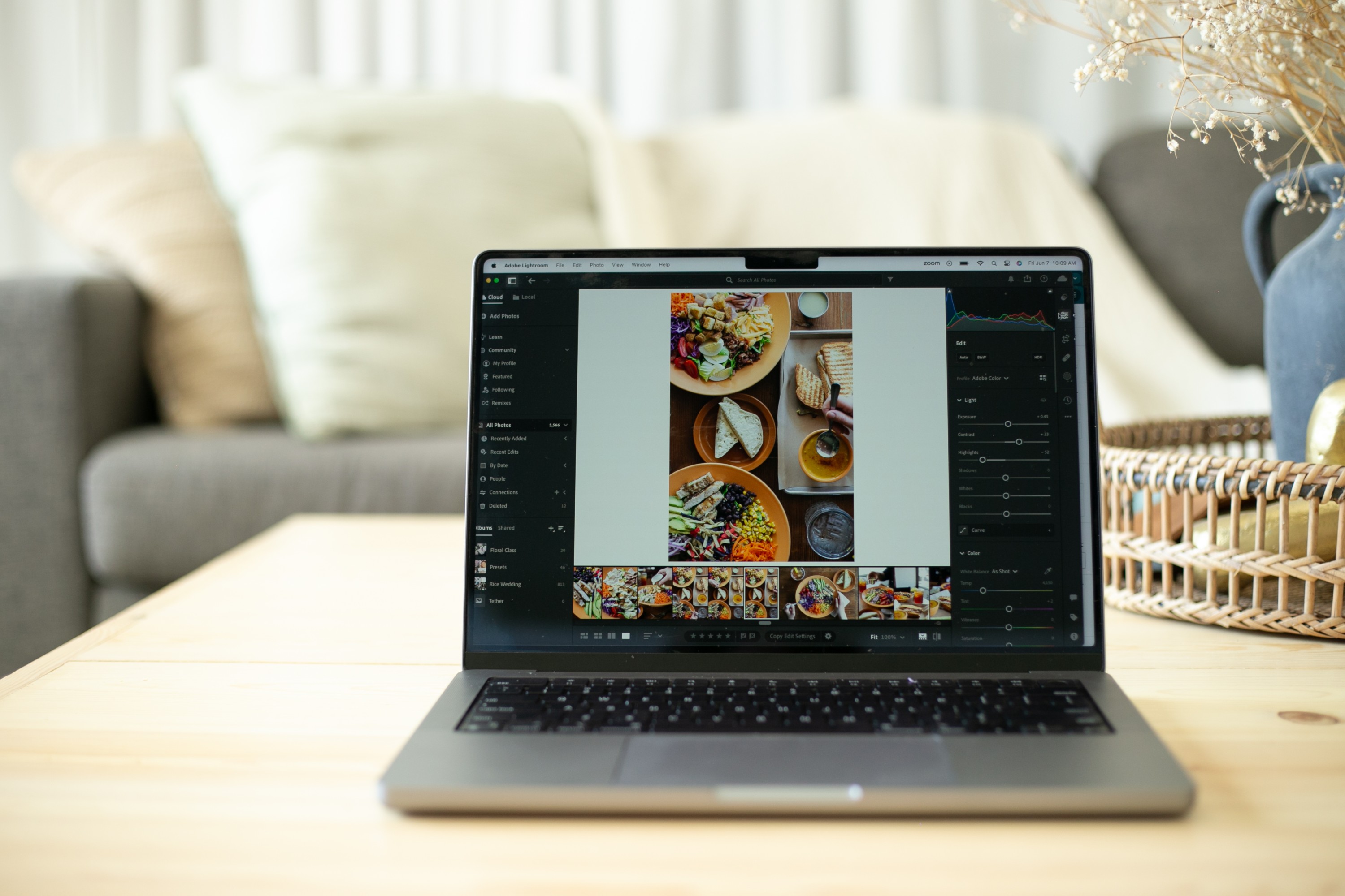 Laptop editing in Lightroom on coffee table in living room
